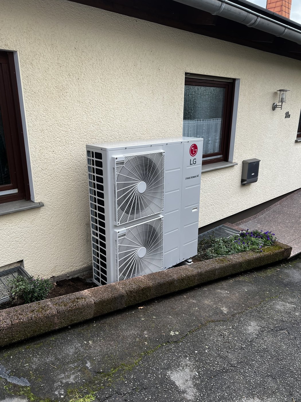 Installierte Wärmepumpen-Außeneinheit an einem Wohnhaus